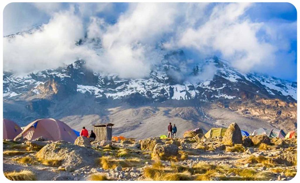 camp setup on Kilimanjaro at sunset, showing modern tents.